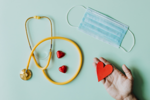 stethoscope, medical mask, and hearts on a blue backdrop
